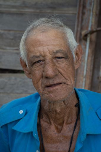 A vertical portrait of an old male looking at the camera in Matanzas, Cuba