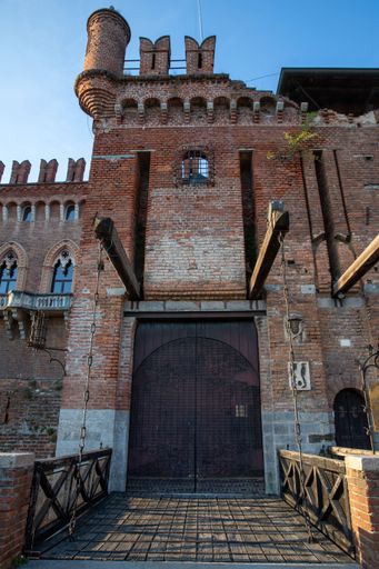 A low angle shot of the Carimate Castle with wooden gates against blue sky in Lombardy, Italy