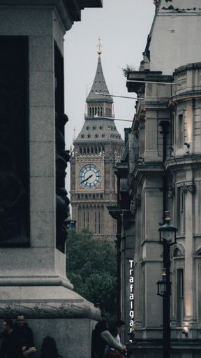 A vertical shot of a tower with a clock in a gloomy weather