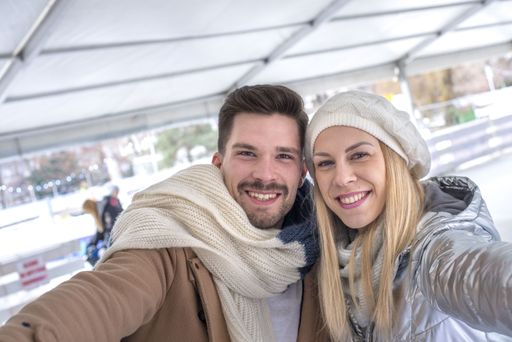 A closeup portrait of a happy smiling Caucasian couple taking a selfie in a winter park