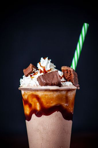 A vertical shot of a milkshake with a dark background
