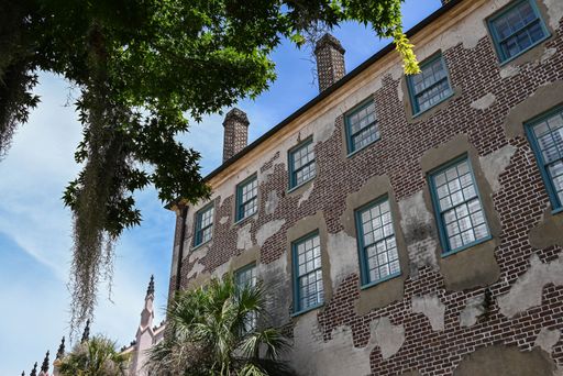 A low-angle shot of a building with brick wall facade against the blue sky