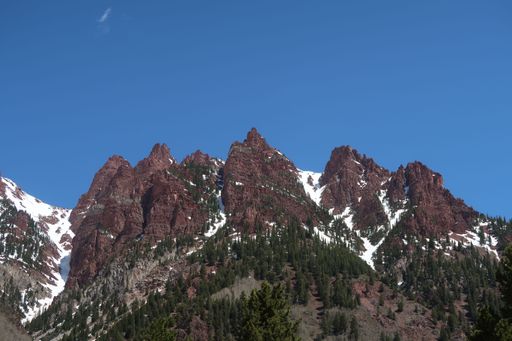 A scenic view of rocky mountains covered with snow and pine forests in Colorado