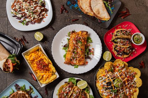 An overhead shot of traditional Mexican dishes like tacos and enchiladas on a table at a restaurant