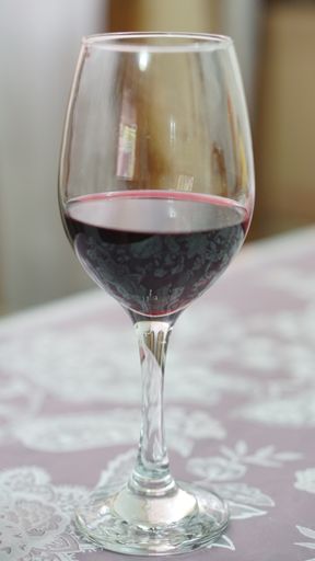 A vertical shot of a glass of wine on the table