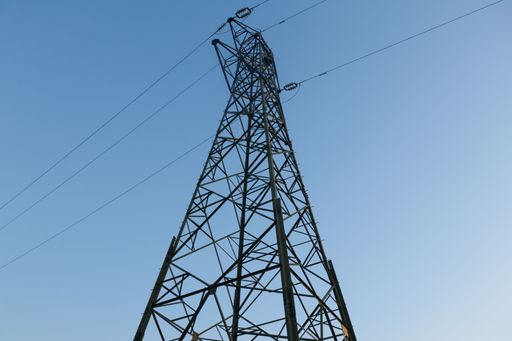 A low angle shot of a tall steel tower under the blue sky