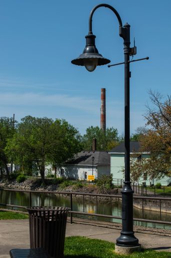 A beautiful shot of a tall street lamp and a public garbage can