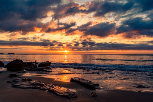 A breathtaking scenery of a sandy beach on a beautiful sunset background