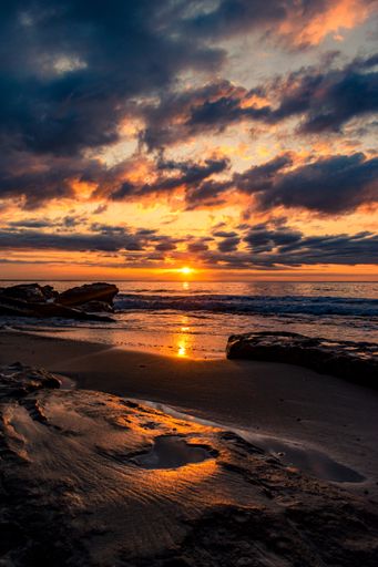 A breathtaking scenery of a sandy beach on a beautiful sunset background