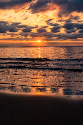 A breathtaking scenery of a sandy beach on a beautiful sunset background