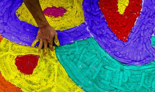 A high angle shot of a person hand painting the ground with chalk in Nepal