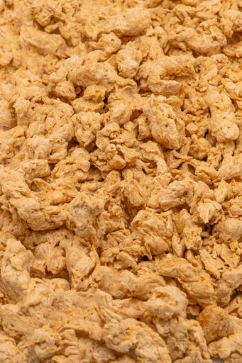 Textured pea protein background. Close up macro shot. It is used to replace ground meat.
