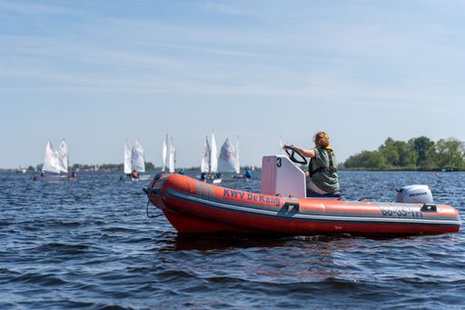 A closeup shot of a sailing instructor looking to the sailboats and giving instructions