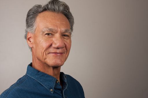 Heads shot Portrait  of a mature man 60 plus wearing a dark blue denim shirt