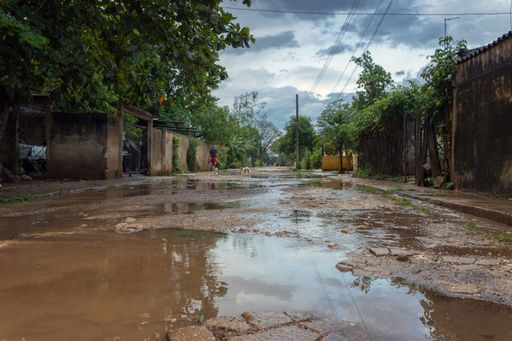 A road with puddles after rain surrounded by houses in the Maximo Gomez village, Cuba