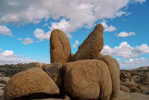 Red rocks against a blue cloudy sky on a sunny day in a desert