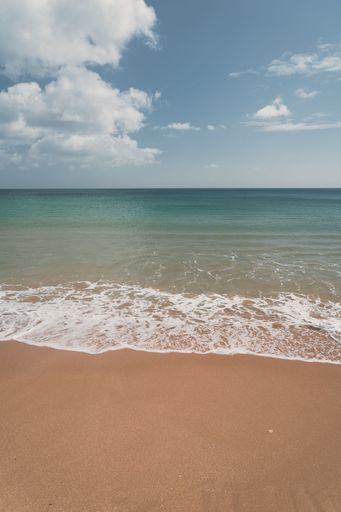 The soft ocean waves with foam on a sandy beach