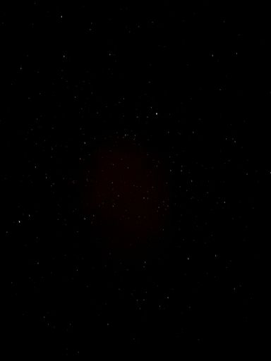 A vertical shot of a black sky with stars at night