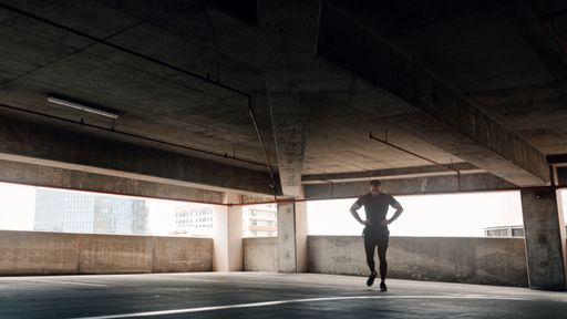 A caucasian male  working out in downtown parking garage in Florida