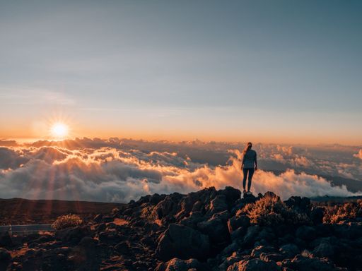 A beautiful sunset over the Haleakala (East Maui Volcano) with a female tourist on Maui, Hawaii
