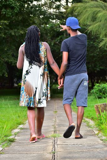A vertical shot of a couple holding hands in a park