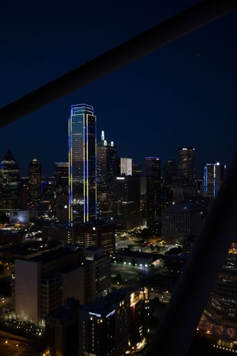 A vertical shot of illuminated modern skyscrapers at night in Downtown Dallas, Texas