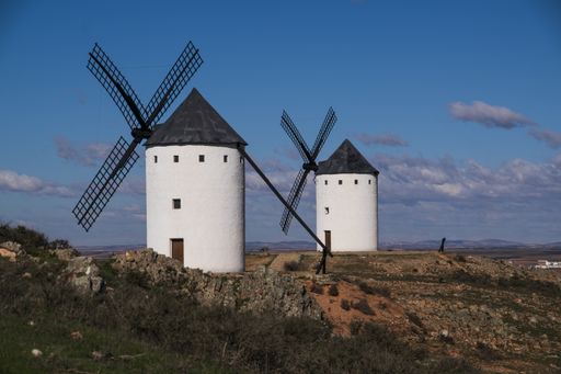 A beautiful shot of white windmills in the field under a blue sky