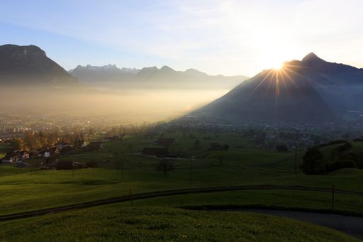 An aerial shot of a mountain landscape with a big village during a sunrise