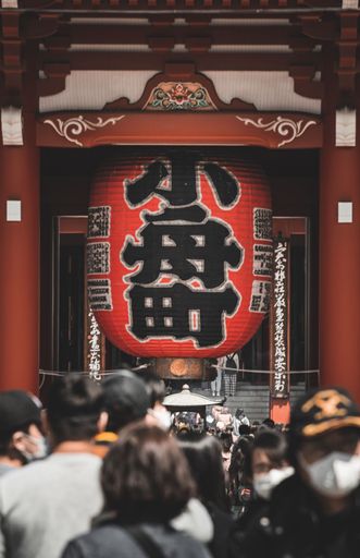 A vertical shot of people entering the Senso-ji Buddhist temple in Asakusa, Tokyo, Japan