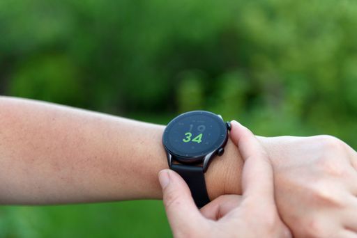 A closeup of a person checking the time on a smartwatch outdoors