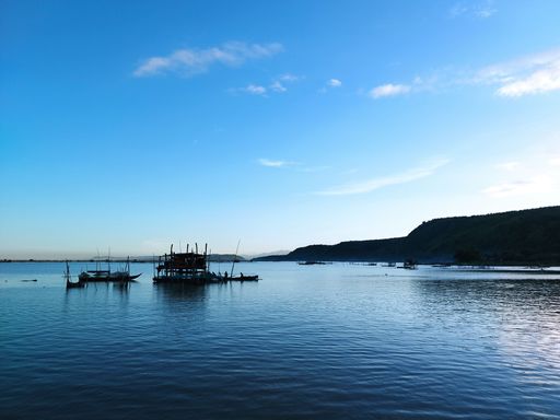 An aerial view of floating boats in sea under blue bright sky
