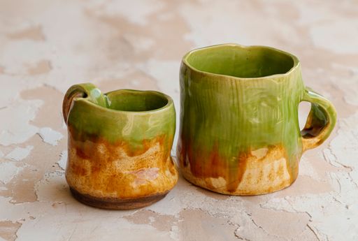 A closeup shot of old ceramic mugs on a grungy wooden surface