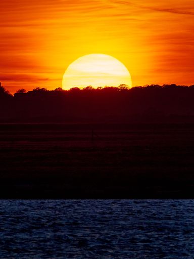 A vertical shot of a beautiful sunset over the backwater at Walton-on-the-Naze, Essex