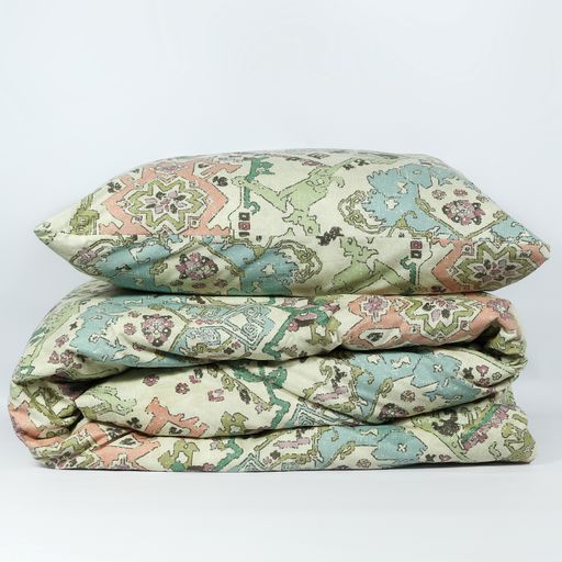 A vertical shot of a decorative patterned pillow and linens isolated on a white background