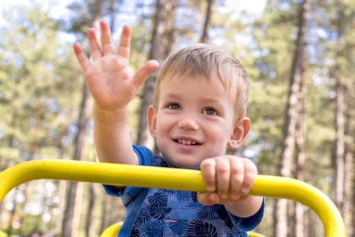 A shallow focus shot of a smiling kid having fun in the playground