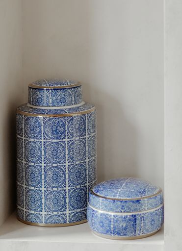 A vertical closeup shot of blue and white ceramic jewelry pots