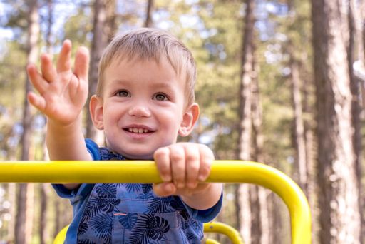 A shallow focus shot of a smiling kid having fun in the playground