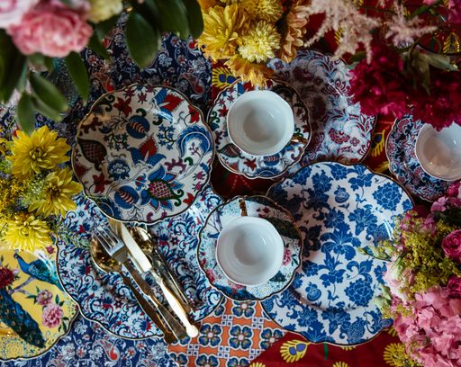A top view of beautiful luxury dishware on the table with colorful flowers