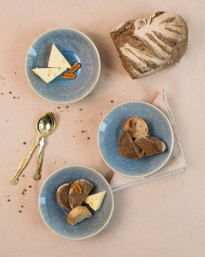 A vertical high angle shot of a breakfast table with bread, cheese and snacks