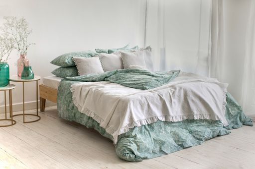 A bedroom with a blue and white patterned linen bed and decorations