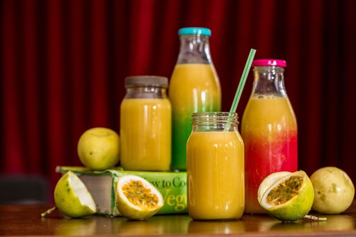 Glass bottles of fresh passion fruit and apple juice
