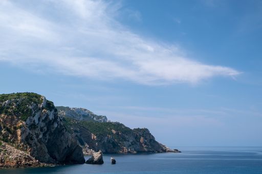A beautiful ocean surrounded by rocky hills during daytime