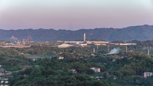An aerial view of a small town with forested mountains