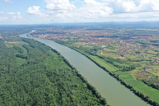 A high angle shot of the river between the Bosnia and Herzegovina under a blue cloudy sky at daytime