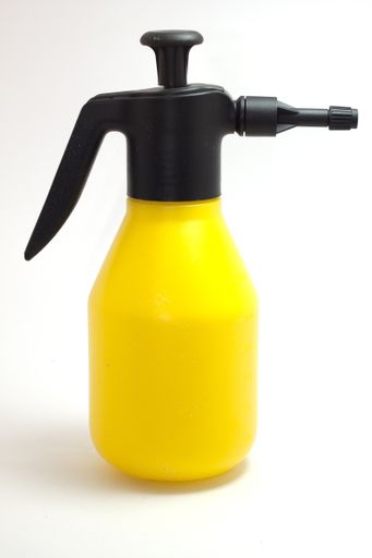 A vertical shot of a yellow gardening tool on an isolated background