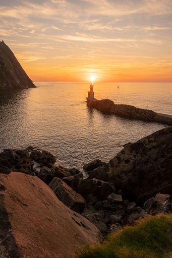 A vertical shot of a sunset sky over the lighthouse on the bay of Pasaia in San Juan, Basque Country
