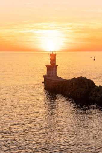 A vertical shot of a sunset sky over the lighthouse on the bay of Pasaia in San Juan, Basque Country