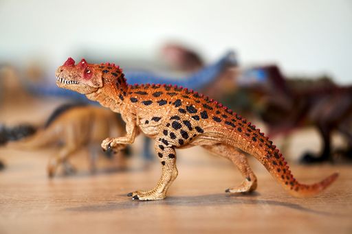 A closeup of a Schleich brand Ceratosaurus toy figurine on a table