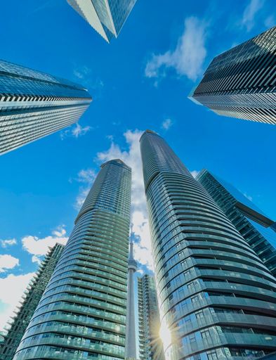 A vertical low angle shot of beautiful skyscrapers against a blue sky in downtown Toronto, Canada