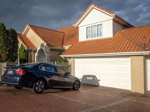 BMW 323i car in front of white suburban house with garage. Auckland, New Zealand - May 20, 2022